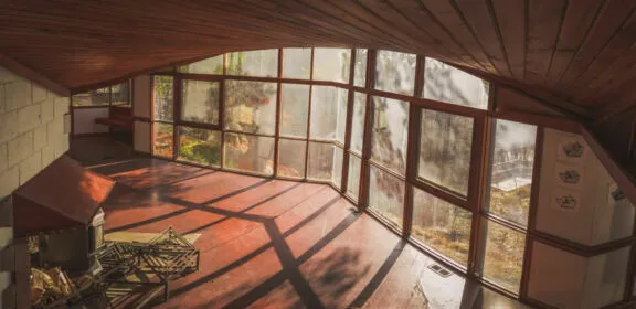 Room with floor-to-ceiling windows and a curved wood-slat ceiling.