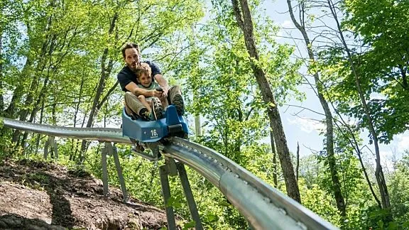 Adult and child sledding at Camp Fortune.