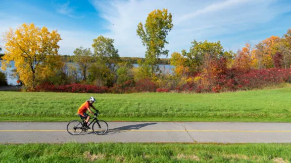 Cycliste sur le sentier polyvalent longeant la rive sud de la rivière des Outaouais, à l'automne.