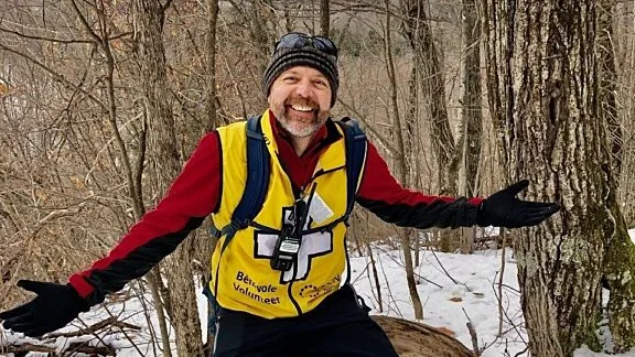 Photo d'un bénévole en hiver, avec sa veste de bénévole.