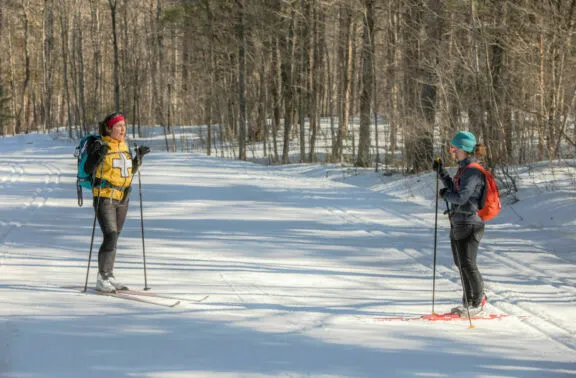 Volunteer ski patroller talking with a user