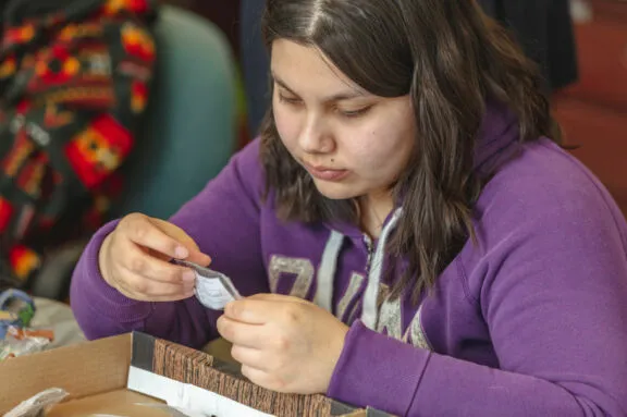 Student holding a small bagged artifact