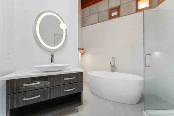 Washroom with standing shower and separate bath, as well as a floating style modern sink.