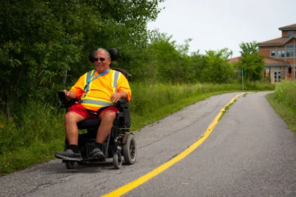 Personne utilisant un véhicule assisté sur un sentier du parc de la Gatineau.