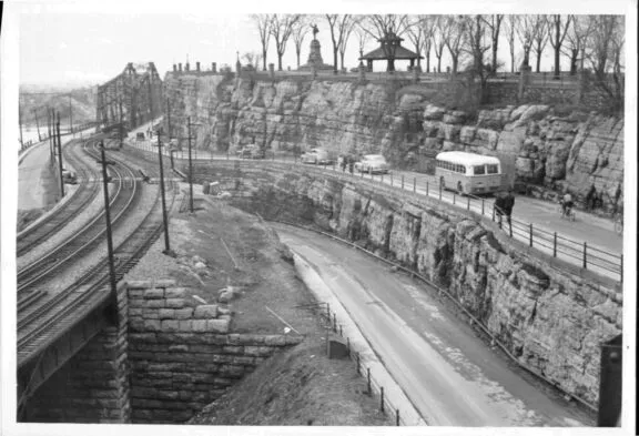 View on the Alexandra Bridge and Nepean Point featuring a statue and a gazebo; train tracks next to Rideau Canal Locks with bus travelling from Ottawa to Hull, 1950s. Credit: City of Ottawa