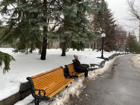 A person sitting on bench in Winter.