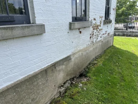 Visible damage to the masonry and foundation.