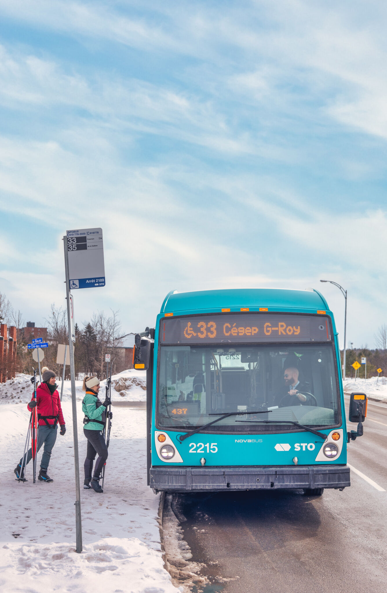 Des personnes qui prennent l'autobus avec leurs skis.