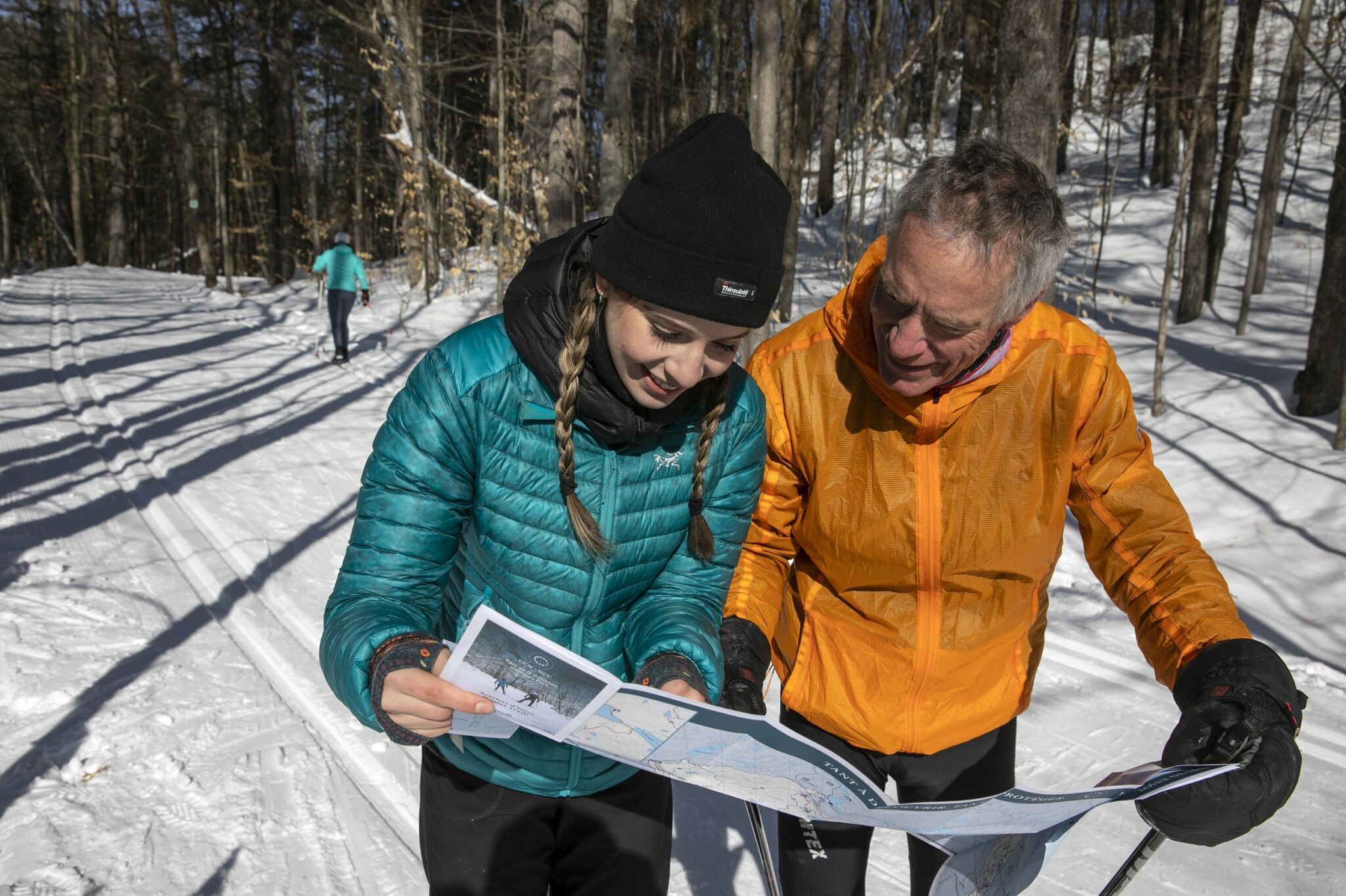 Des personnes qui regardent une carte des sentiers d'hiver.