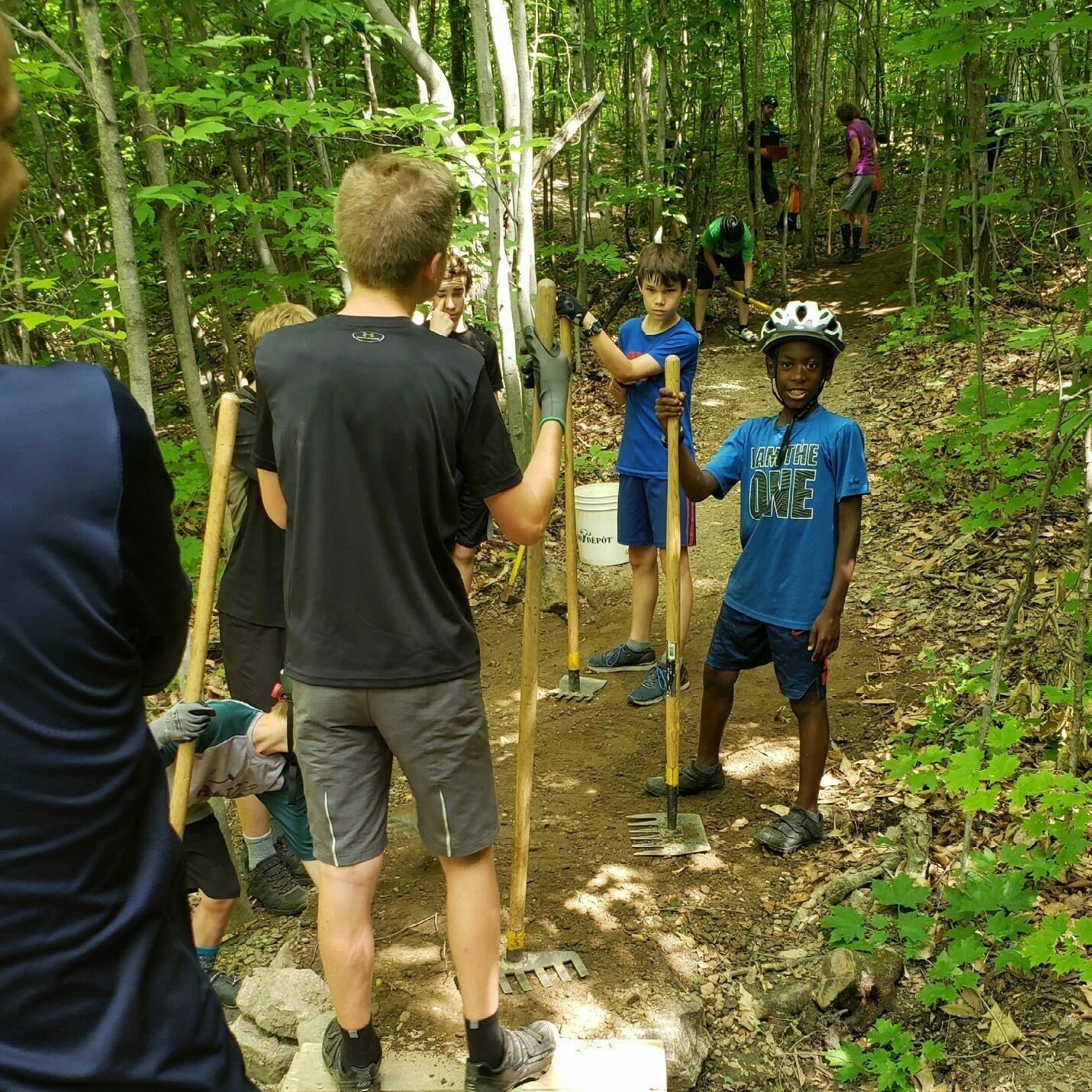 Enfants et adolescents participant à l'entretien d'un sentier de randonnée.