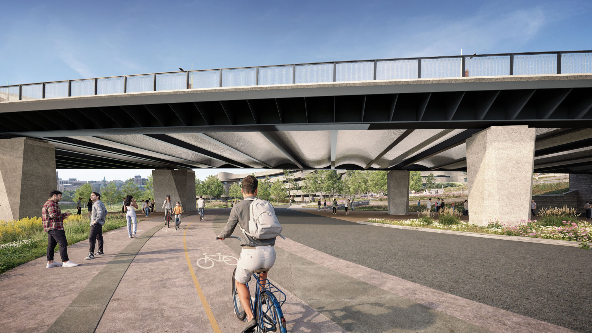 Le sentier continue sous l’approche du pont à Gatineau et se raccorde au sentier des Voyageurs. Les gens marchent et font du vélo sur le sentier, entourés de verdure et d’arbres. La structure du pont avec des supports en béton et des rampes métalliques est visible.