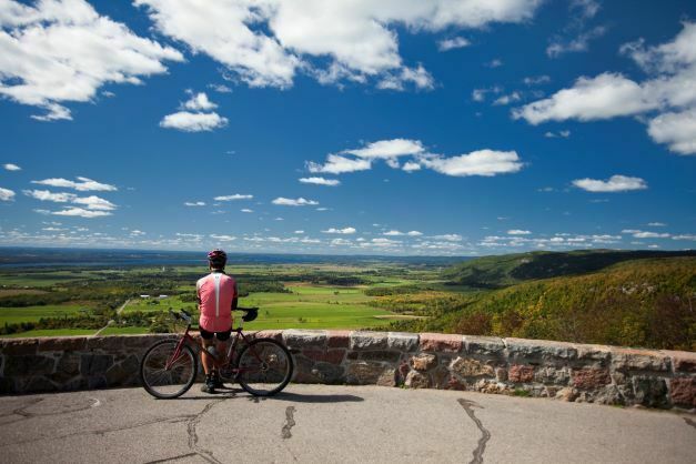 Cycliste admirant la vue à la pointe du belvédère Champlain.