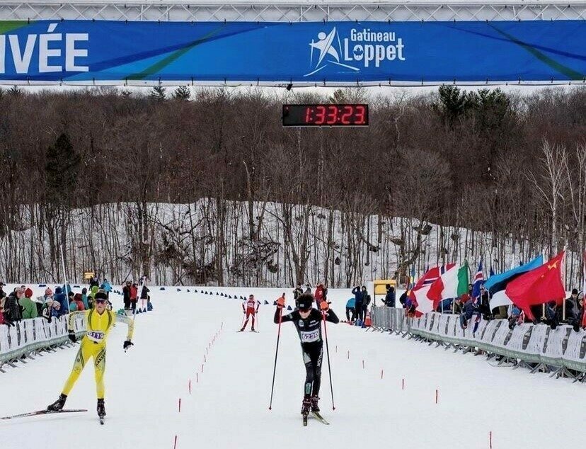 Personnes en ski de fond arrivant à la ligne d’arrivée de la Gatineau Loppet.