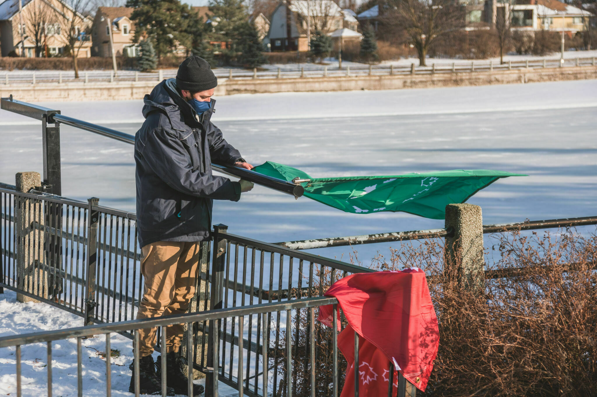Man changing the flag on the Rideau Canal Skateway